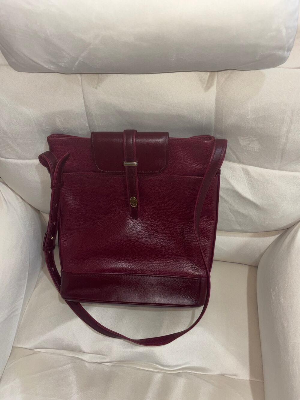 vintage Cartier leather bucket bag in a burgundy color with gold-tone hardware